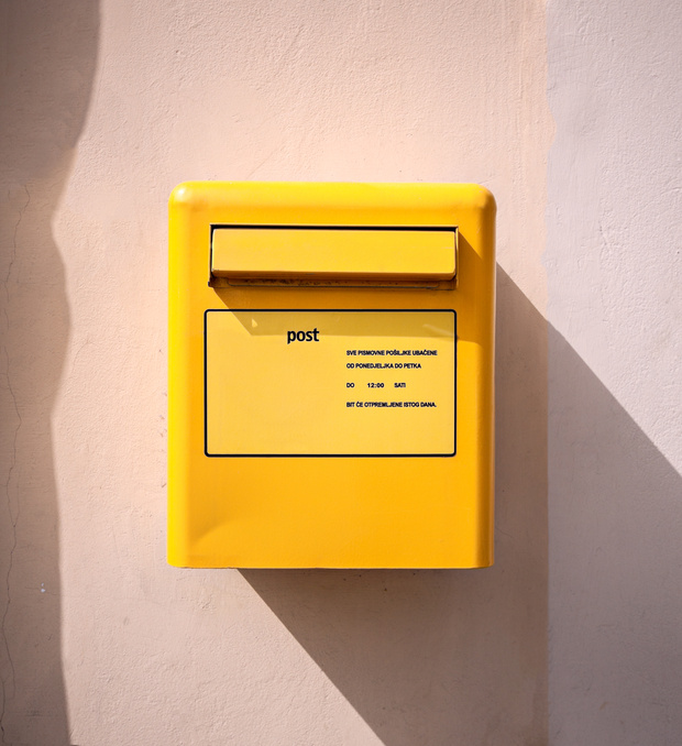 letter mail delivery post yellow box at wall